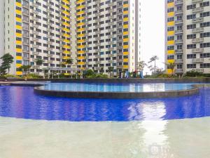 una grande piscina d'acqua di fronte a edifici alti di Fancy and Comfy 2BR Apartment at Springlake Summarecon By Travelio a Bekasi