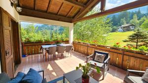 a screened in porch with a table and chairs at BAITA GRUEPEUN - "baita Laner" in Frassilongo