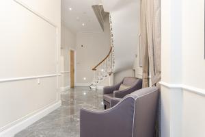 a therapy room with two chairs and a staircase at Cleveland Residences Chelsea in London