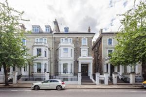 a car parked in front of a large house at Cleveland Residences Chelsea in London