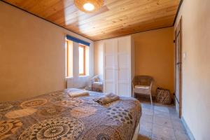 a bedroom with a bed and a wooden ceiling at Maison Time-out in Villevieille