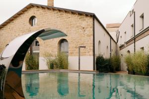 巴勒莫Spasimo Hôtellerie的砖楼前的游泳池