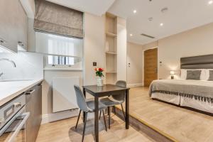 a bedroom with a bed and a desk with a table at Cleveland Residences Chelsea in London