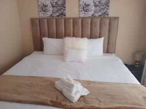 a pile of white towels sitting on a bed at Elim Rest Place in Fisherhaven +16 photos