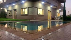 une maison avec piscine la nuit dans l'établissement Suite nature montagne et petit déjeuner Villa Fatima, à Fès