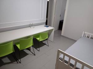 a room with a white table and green chairs at apto simples,3min centro, 3 min da Unimed com wifi in Araçatuba +31 photos