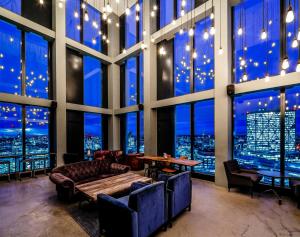 Habitación con sofá, mesa y ventanas. en Chapter Spitalfields in London, en Londres