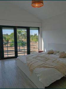 a bedroom with a large bed with a large window at Villa Palmela Resort V5 Piscina privado in Quinta do Anjo