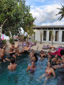 eine Gruppe von Personen, die im Pool sitzen in der Unterkunft Lushy Hostel Nusa Penida in Nusa Penida