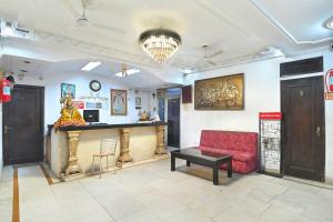 a lobby with a red couch and a bar at Hotel Ashoka Continental in New Delhi