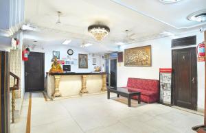 a lobby with a red couch and a bar at Hotel Ashoka Continental in New Delhi