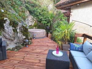 a patio with a couch and a table on a patio at L'appartement enchanteur d'Angon in Talloires +3 photos