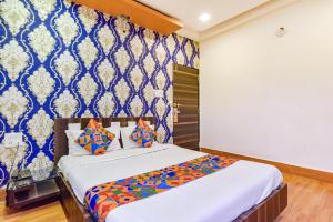 Un dormitorio con una cama con papel pintado azul y blanco. en FabHotel Shri Shyam Palace, en Ujjain 19 fotos más