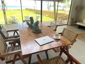 una mesa de madera con sillas y un ordenador portátil. en Private Beachfront El Nido - Sa Dulo Villa Diapila Bay, en El Nido