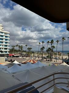 a view of a beach with palm trees and umbrellas at Ithaki Phinikoudes Apartments No. 106 in Larnaka