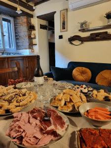 stół z wieloma talerzami z jedzeniem w obiekcie Casa della Rosa w mieście Cortona