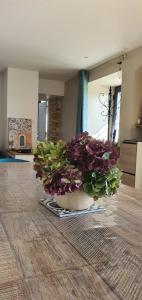 a vase filled with purple flowers sitting on a floor at Le Clos Gagné in Bais