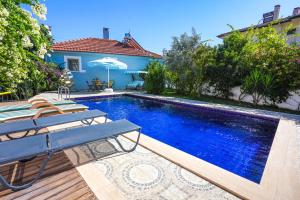 a swimming pool with a table and an umbrella at Villa Misli - Heart of Dalyan and Newly Renovated in Dalyan