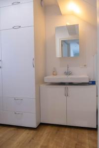 エグモント・アーン・ゼーにあるGestrandの洗面台と鏡のある白いバスルーム