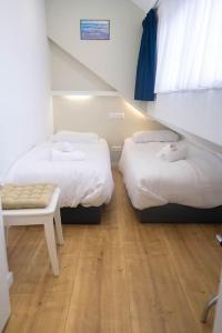 エグモント・アーン・ゼーにあるGestrandのベッド2台と椅子が置かれた部屋