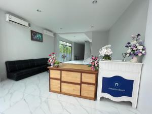 a living room with a black couch and flowers at Lamoon Trang in Ban Phlu Phli +40 photos