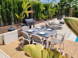 a patio with a table and chairs and a grill at La Perla Blanca in Benijófar