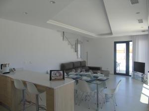 a kitchen and dining room with a table and chairs at La Perla Blanca in Benijófar +15 photos