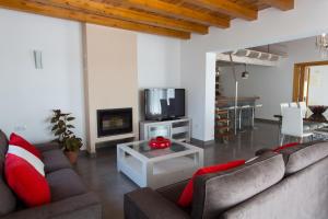 a living room with two couches and a tv at Ses Viñas De Cas Baixero in La Mola