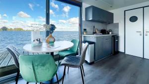 a kitchen and dining room with a table and chairs at Golfzicht by Droomvilla in Uitgeest