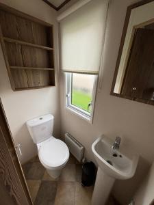 ein Badezimmer mit Toilette und Waschbecken in der Unterkunft The Retreat 34, Central Heating, Pet friendly, WiFi - Golden Palm Resort - Meadow Lakes Caravan & Lodge Hire in Chapel Saint Leonards + 3 Fotos