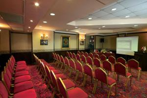 une salle de conférence avec des chaises rouges et un écran dans l'établissement Germir Palas Hotel - Special Class, à Istanbul