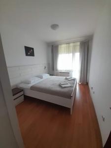 une chambre avec un lit blanc et une fenêtre dans l'établissement Belvedere Holiday Club H80, à Bansko 9 autres photos
