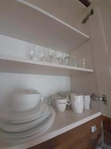 une étagère avec des bols et des tasses sur un comptoir dans l'établissement Belvedere Holiday Club H80, à Bansko