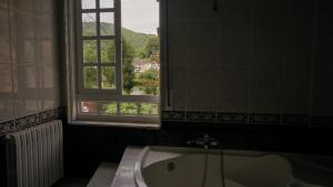 a bathroom with a bath tub and a window at Pensión Castro Parrillada in Samos +41 photos