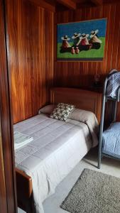 a small bed in a room with wooden walls at Casa Julia De Lozano in Rinlo