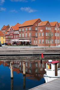 um barco sentado na água ao lado de um edifício em Tornøes Hotel em Kerteminde