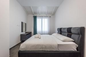 Royal Hill Apartments by PS في دوريس: غرفة نوم بها سرير كبير وتلفزيون