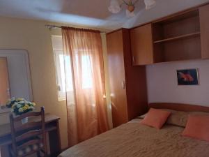 sypialnia z łóżkiem i oknem w obiekcie Apartment Ljilja w mieście Zaton