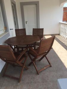 ein Holztisch und Stühle auf einer Terrasse in der Unterkunft Apartment Tihana in Vir