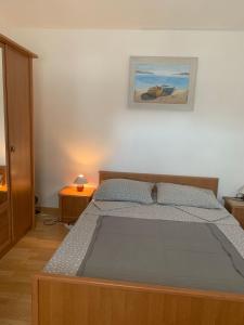 ein Bett in einem Schlafzimmer mit einem Bild an der Wand in der Unterkunft Apartment Tihana in Vir