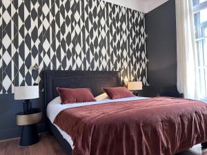 a bedroom with a bed and a black and white patterned wall at Le Grand Hotel in Sète +27 photos