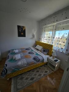 a bedroom with a large bed with a yellow headboard at Iskra Apartment in Kragujevac