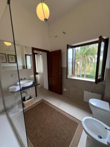 a bathroom with a toilet and a sink and a window at Domus Orestea Luxury Suites in Palermo