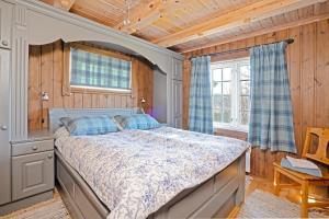 a bedroom with a bed in a room with wooden walls at Tovebu Superior 9-sengshytte in Geilo