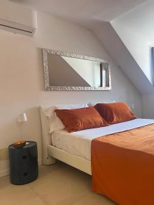 a bedroom with a bed with a mirror on the wall at Domus Orestea Luxury Suites in Palermo