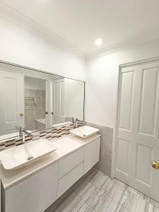 a bathroom with two sinks and a large mirror at Cozy Room in Modern and Peaceful Home - BH5 in Baulkham Hills