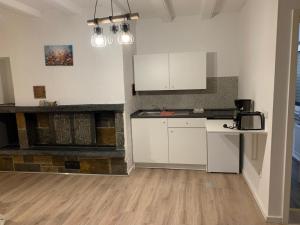 eine leere Küche mit weißen Schränken und einem Kamin in der Unterkunft Fewo Meschede Eversberg Radring in Meschede