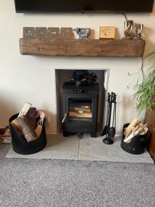 een open haard met een fornuis in de woonkamer bij Ramsay Lane in Lossiemouth