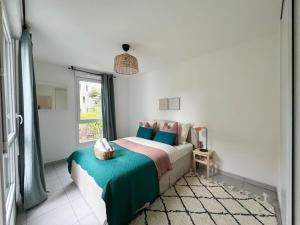 a bedroom with a bed with a green blanket and a window at Le Céleste in Toulouse