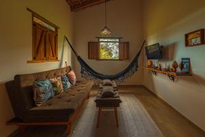 ein Wohnzimmer mit Couch und Hängematte in der Unterkunft Chalés Samambaia 1 in Bananeiras